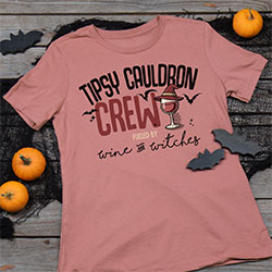 Your Name Crew, Fueled By Wine And Witches, next to a wine glass with a witch's hat and flanked by bats on a mauve premium ladies tee.