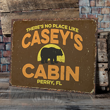 A754 Rustic Cabin - There's No Place Like Your Name Cabin, Your Location, around the silhouette of a black bear, on a tine sign.