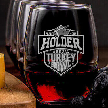 A633 Turkey Bowl - A football with turkey legs and the phrase feast mode, above Your Name Annual Turkey Bowl in a football style logo, on an engraved stemless wineglass.