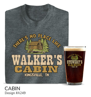 A249 | Cabin - There's No Place Like Your Name Cabin, Your Location, around a classic log cabin flanked by pine trees on a blue tee, 2 tone camo hoodie, 2 tone camo baseball hat, color printed pint glass, and ceramic coffee mugs.