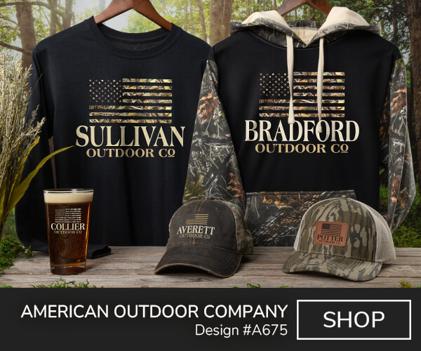A675 | American Outdoor Company - American flag in a camouflage motif above Your Name, Outdoor Company on a black long sleeve T shirt, 2 tone camo hat, 2 tone camo hoodie, color printed pint glass, and a camo trucker hat with patch.