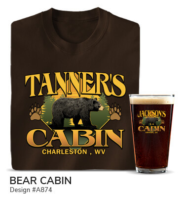 A874 | Bear Cabin - Your Name Cabin, Your Location, around a black bear and two bear paw prints on a brown T shirt and color printed pint glass.